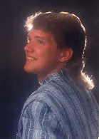 Man in blue plaid shirt smiling