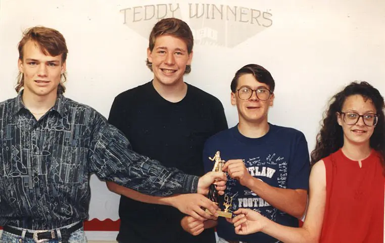 Group holding trophy under "Teddy Winners" sign