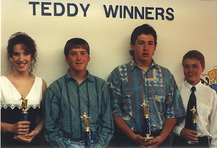 Group of four trophy winners smiling