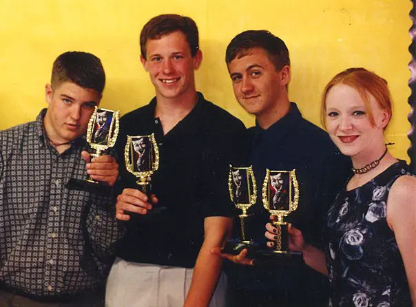 Group of four holding trophies