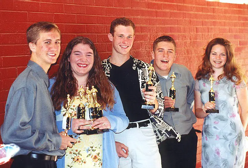 Friends proudly display their trophies together.
