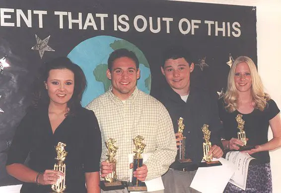 Group holding trophies in front of banner