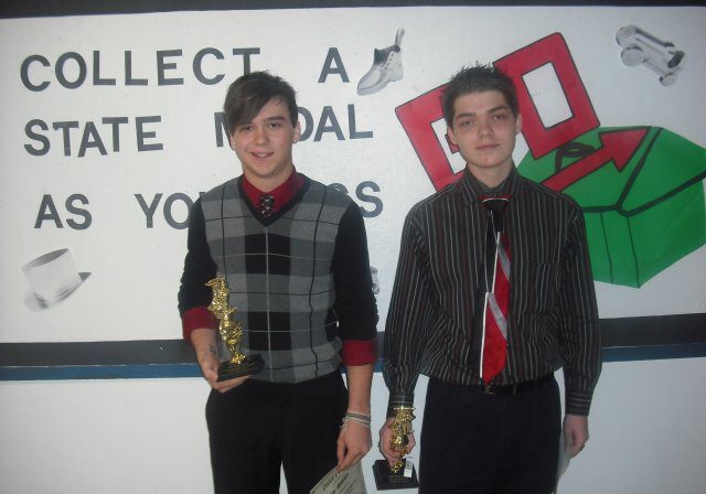 Two young men holding trophies