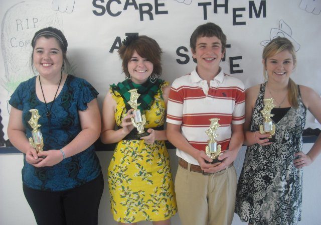 Group of four holding trophies