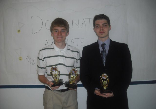 Two people holding trophies