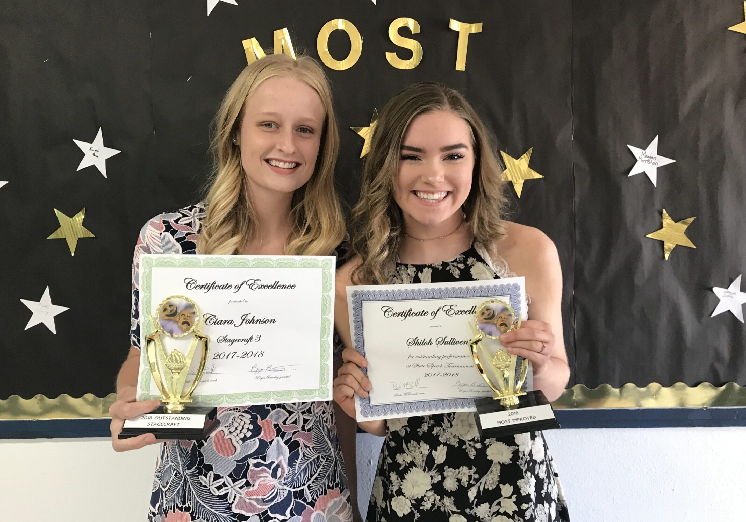 Two smiling women holding certificates