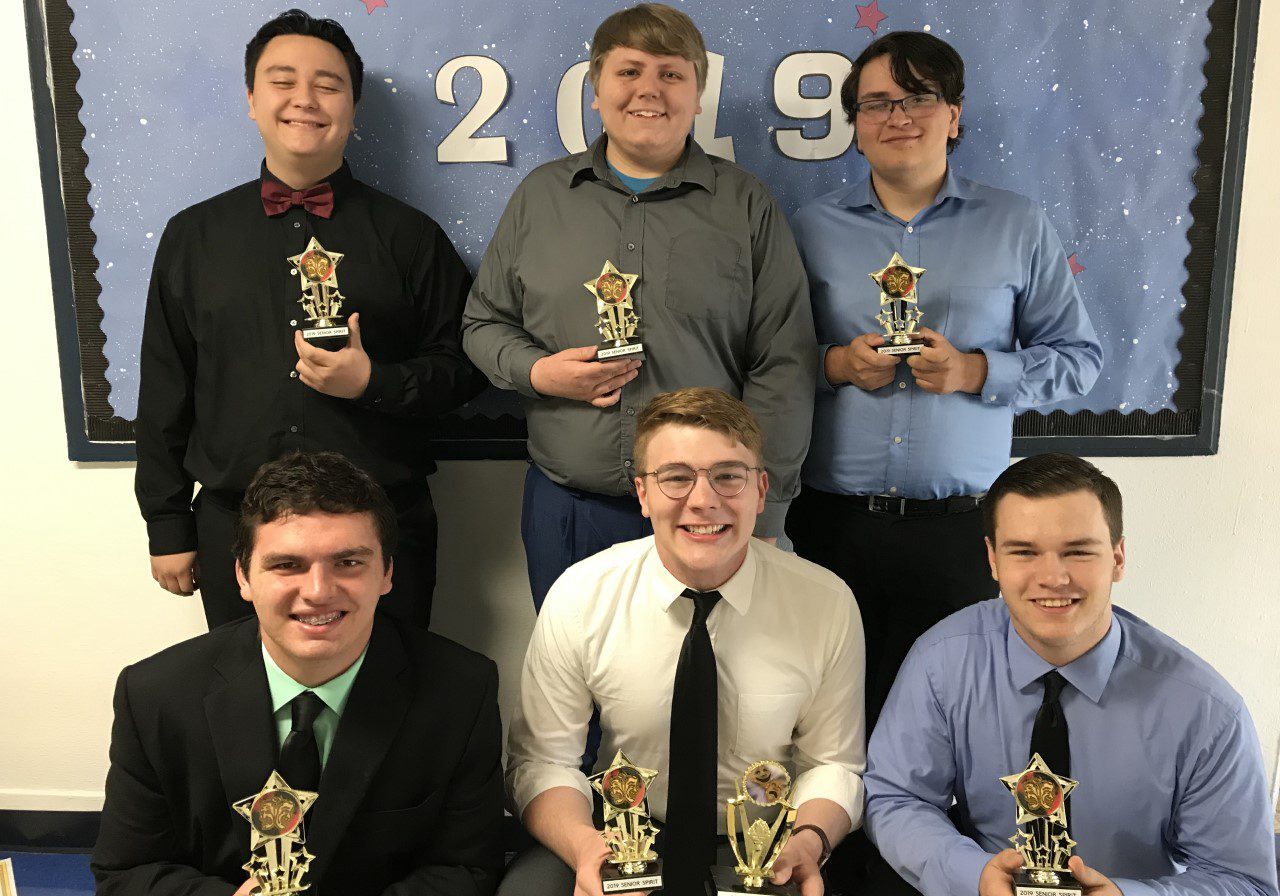 Group of smiling young men with trophies