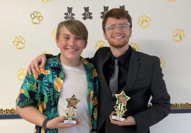 Smiling friends with awards in hand